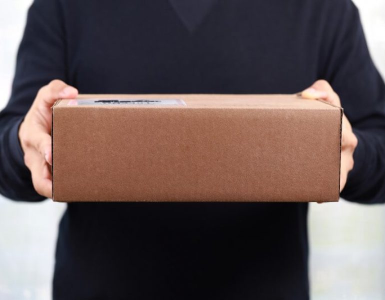closeup-hands-of-delivery-man-holding-package-to-d-CE7WQMT (1)